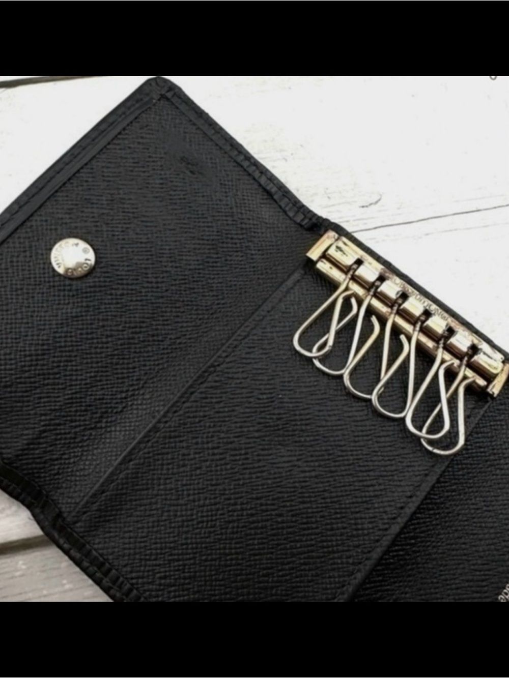 AUTHENTIC Louis Vuitton key holder. Previously owned. Color: Black.